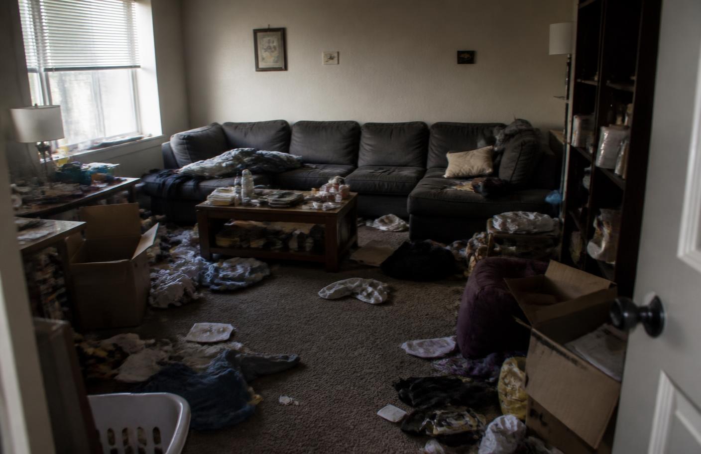 The same living room before cleaning, cluttered and dusty